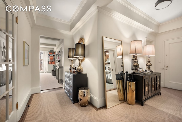 hallway with light colored carpet, baseboards, and ornamental molding