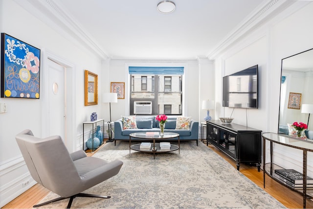 living area featuring cooling unit, crown molding, and wood finished floors