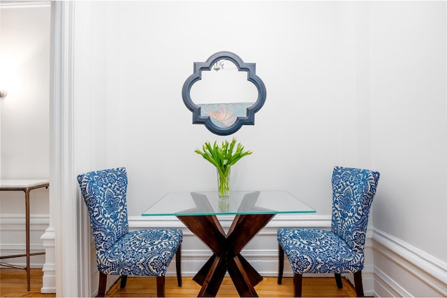 dining room featuring a wainscoted wall and wood finished floors