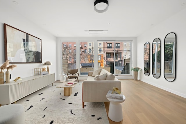 living area with baseboards, visible vents, and light wood finished floors