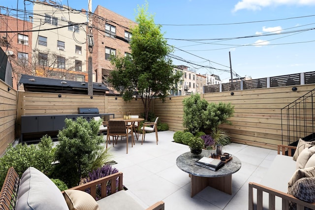 view of patio with outdoor dining space, a fenced backyard, grilling area, and an outdoor living space with a fire pit