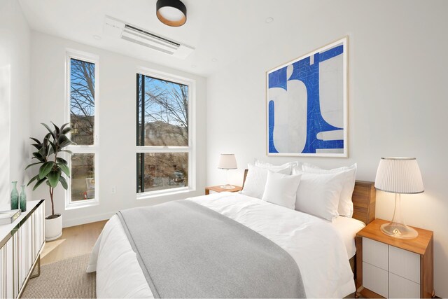 bedroom featuring wood finished floors and visible vents
