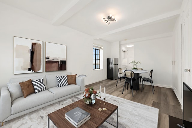 living room featuring beamed ceiling, wood finished floors, and baseboards