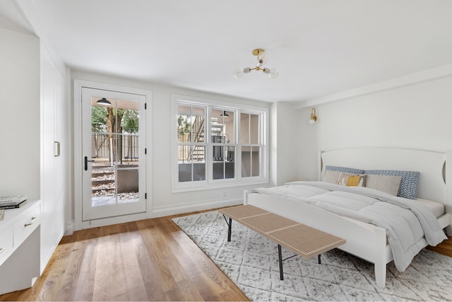 bedroom with light wood-style floors and access to outside