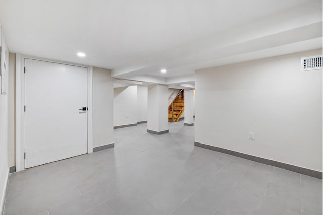 finished below grade area with recessed lighting, visible vents, baseboards, and stairs