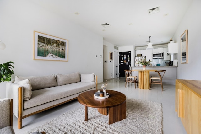 living area with visible vents and light tile patterned floors