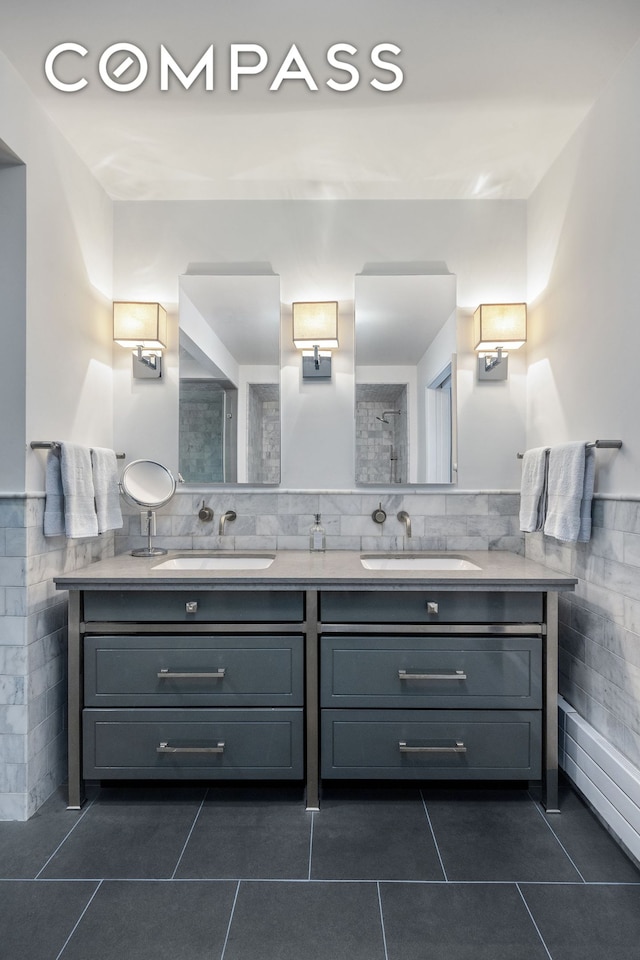 full bathroom featuring tile patterned flooring, a sink, and tile walls