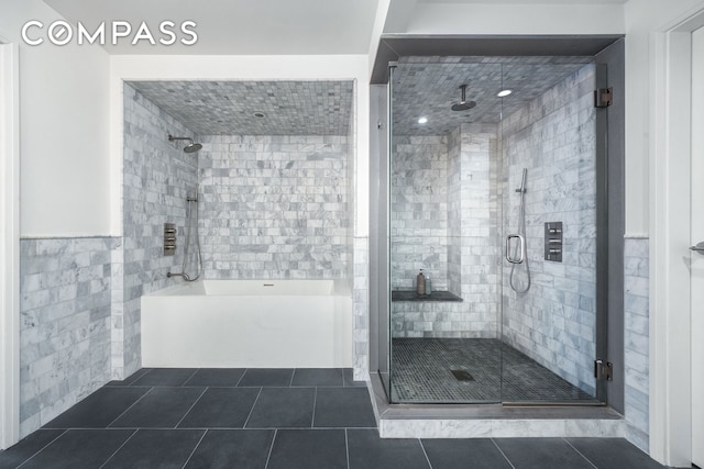 full bathroom with tile walls and tile patterned flooring