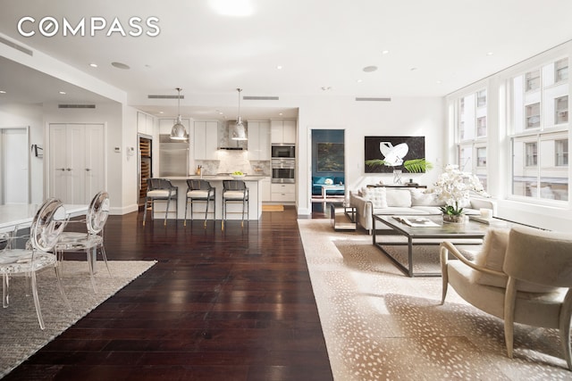 living room with baseboards, hardwood / wood-style floors, visible vents, and recessed lighting