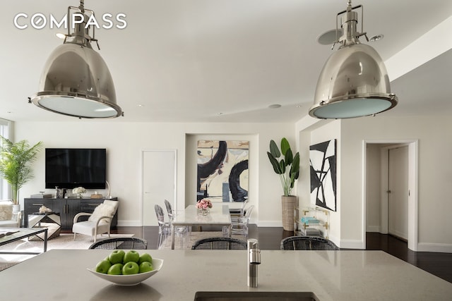 kitchen with open floor plan, baseboards, and decorative light fixtures