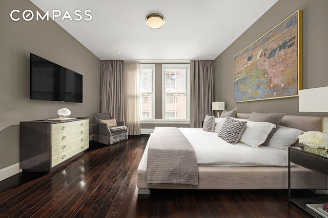 bedroom with wood-type flooring and baseboards