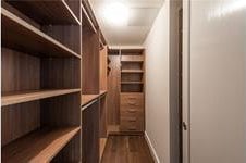 walk in closet with dark wood-type flooring