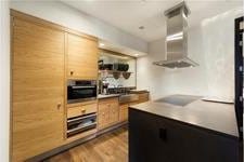 kitchen with wall chimney exhaust hood, dark wood finished floors, and electric stovetop