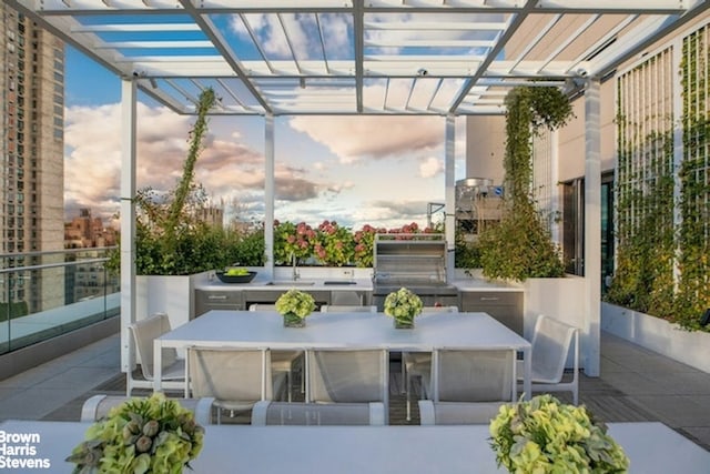 view of patio / terrace with a pergola, outdoor dining area, and a sink