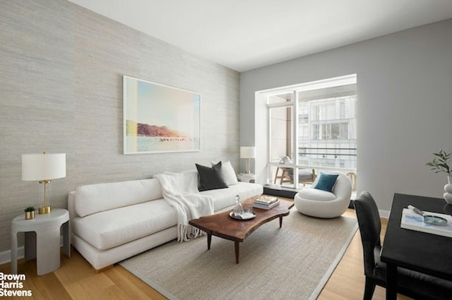 living area featuring light wood finished floors and baseboards