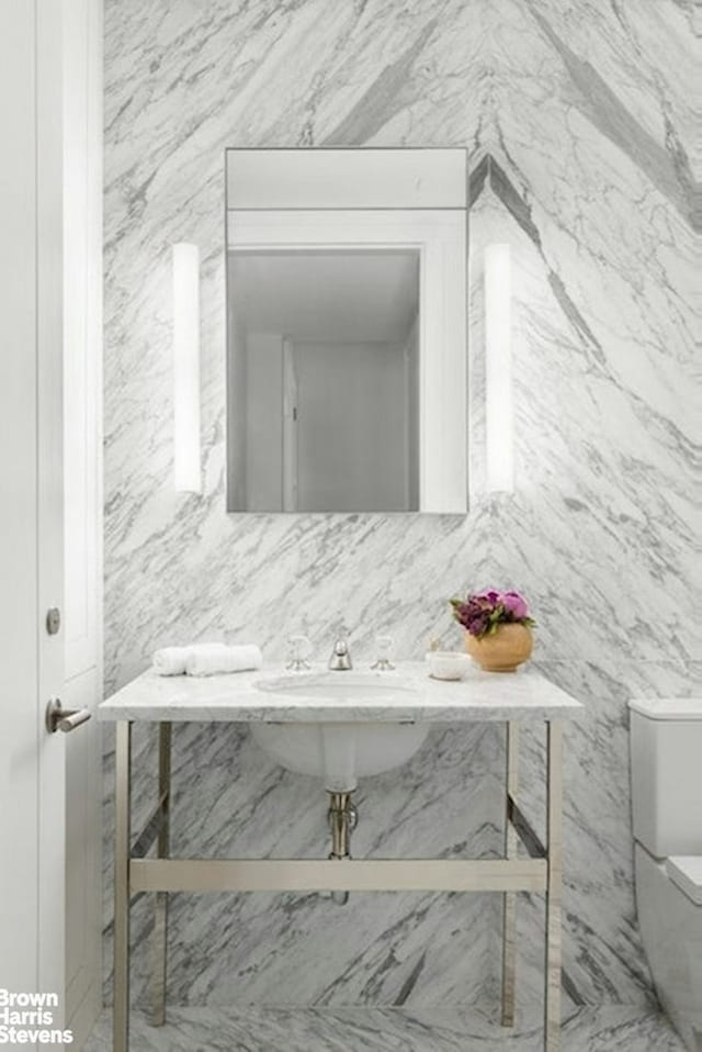 half bathroom with decorative backsplash and toilet