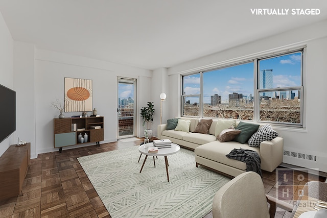 living area with baseboards, a city view, and radiator heating unit