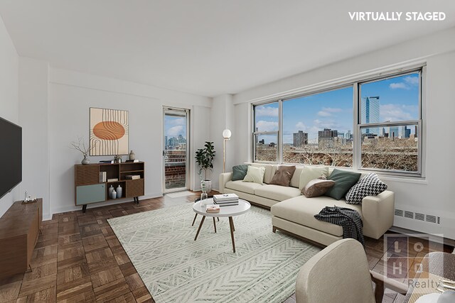 living area featuring baseboards, a view of city, and radiator