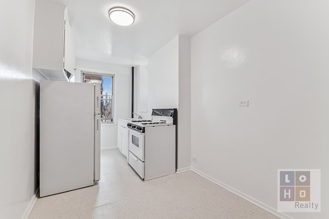 kitchen featuring white appliances, baseboards, and white cabinets