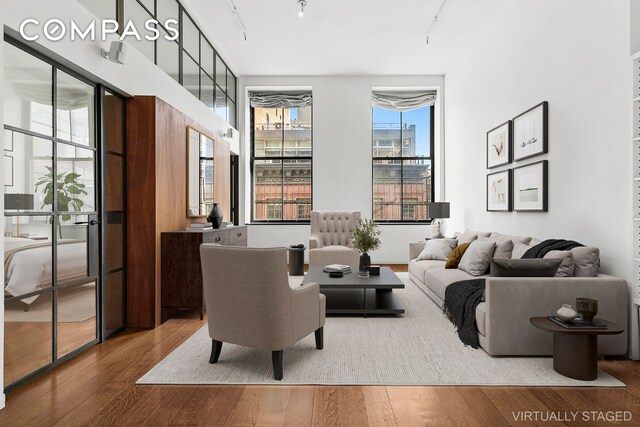 living area with track lighting and wood finished floors