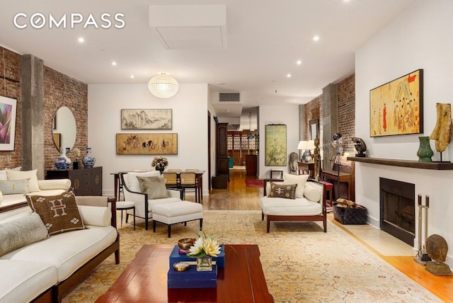 living area with recessed lighting, a fireplace with flush hearth, wood finished floors, and visible vents