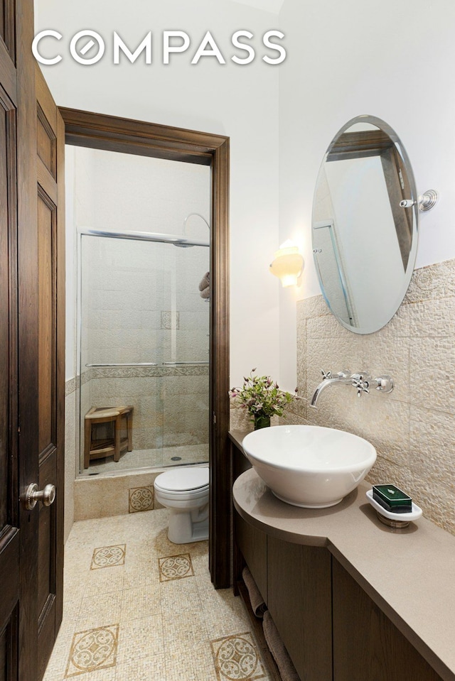 full bath with vanity, backsplash, a stall shower, and toilet