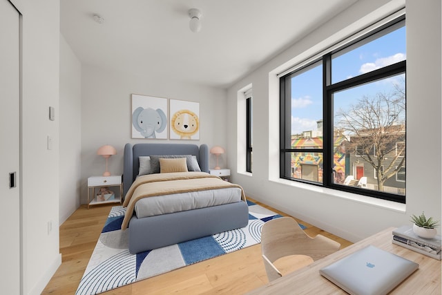 bedroom with light wood-type flooring and baseboards