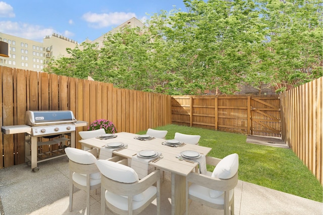 view of patio / terrace with a fenced backyard, a gate, outdoor dining area, and grilling area