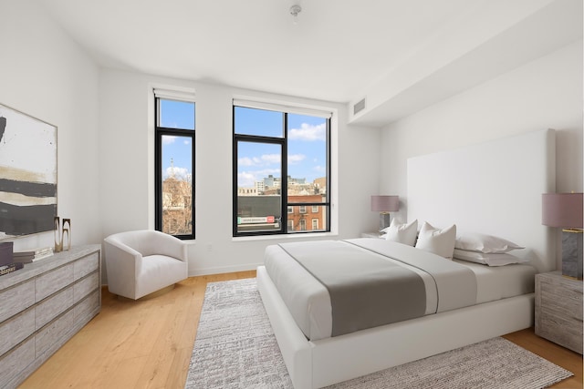 bedroom featuring light wood-type flooring and visible vents