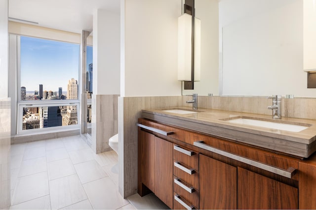 400 5th Ave Unit 43F, New York City, NY 10018 - bathroom featuring double vanity, a wainscoted wall, and tile patterned flooring