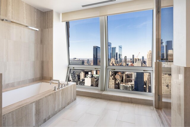 400 5th Ave Unit 43F, New York City, NY 10018 - bathroom with a bath, a skyline view, and tile patterned flooring
