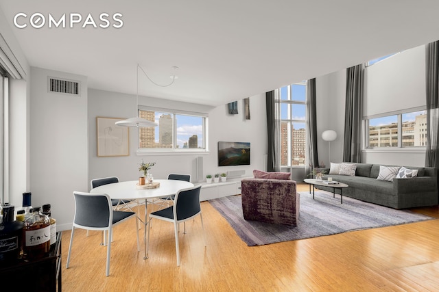 living room featuring a wealth of natural light, wood finished floors, and visible vents