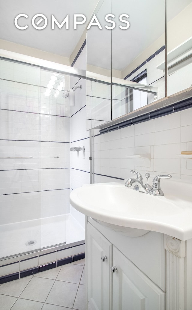full bathroom featuring a shower stall, tasteful backsplash, tile walls, and vanity