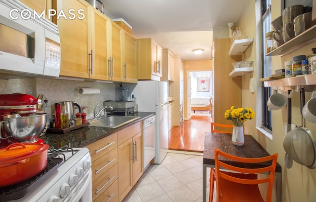 kitchen featuring white appliances, a sink, tasteful backsplash, light tile patterned floors, and open shelves