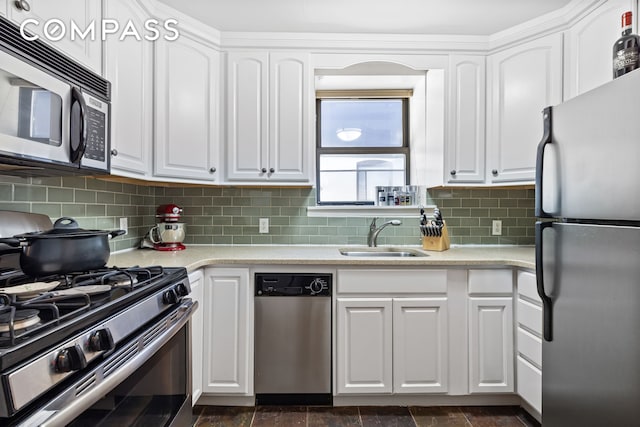 kitchen with a sink, tasteful backsplash, stainless steel appliances, white cabinets, and light countertops