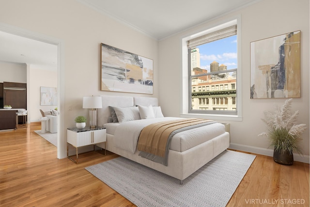 bedroom featuring a view of city, baseboards, crown molding, and light wood finished floors