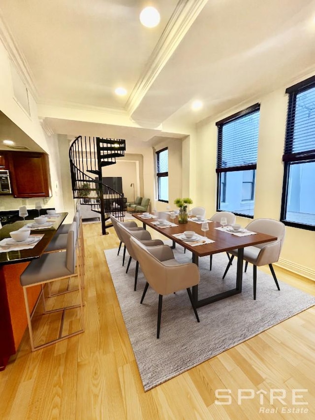 dining room with light wood finished floors, baseboards, stairway, and ornamental molding