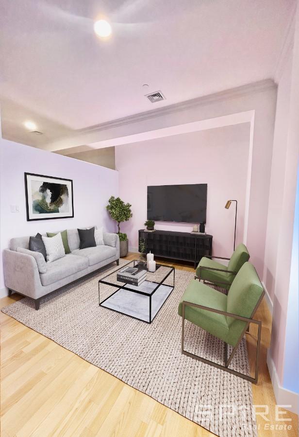 living area featuring ornamental molding, visible vents, baseboards, and wood finished floors