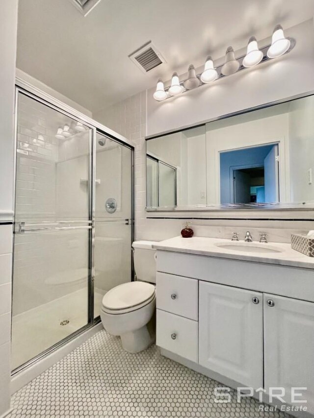 full bath with visible vents, toilet, a shower stall, and vanity