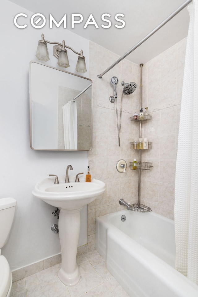 full bath featuring tile patterned floors, shower / bath combination with curtain, toilet, and baseboards