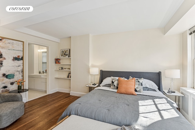 bedroom with visible vents, baseboards, wood finished floors, and connected bathroom