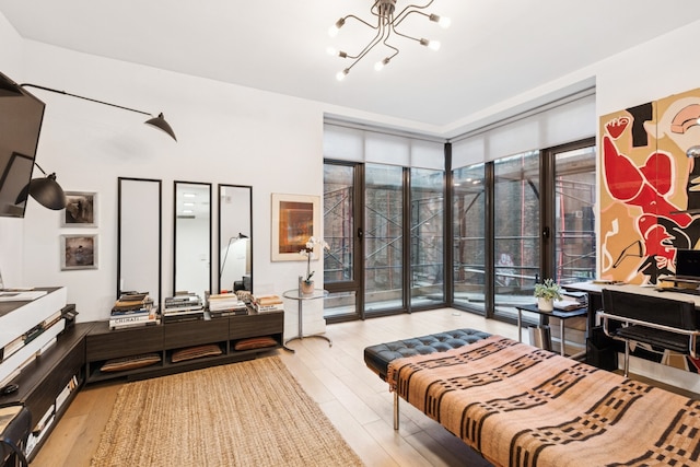 bedroom featuring light wood-type flooring, access to exterior, and a chandelier