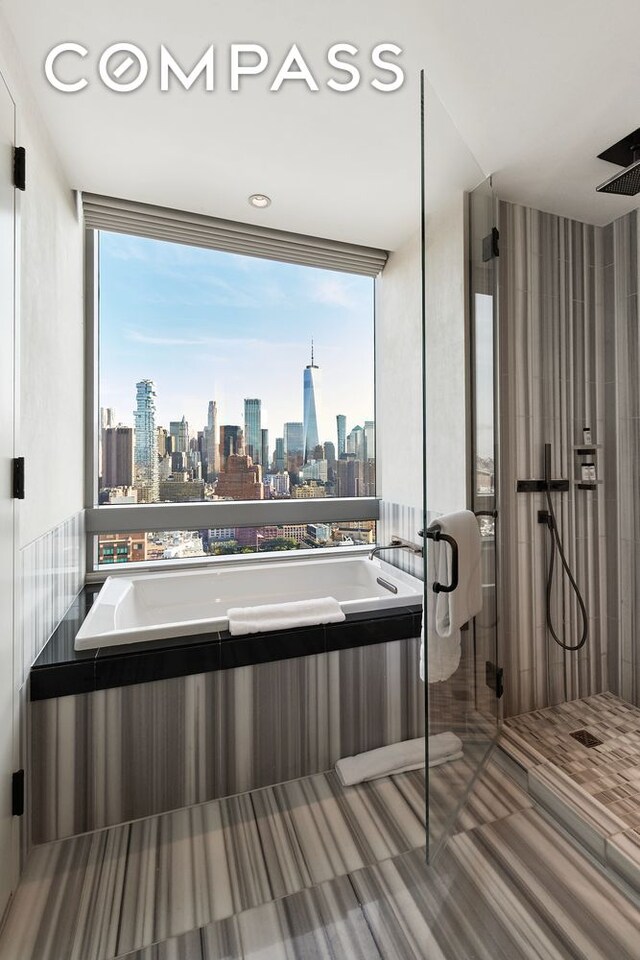 bathroom featuring a view of city, a garden tub, and a stall shower