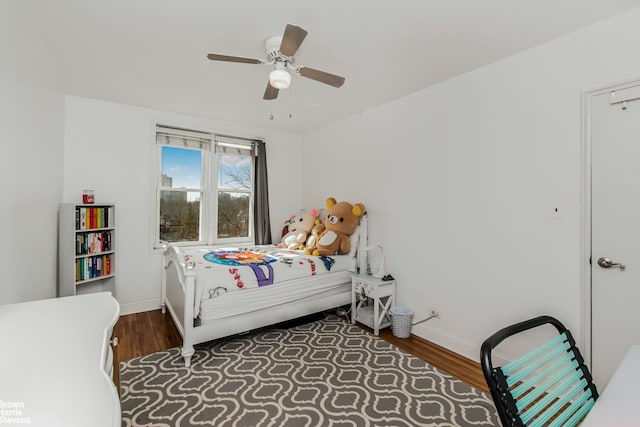 bedroom with ceiling fan, baseboards, and wood finished floors
