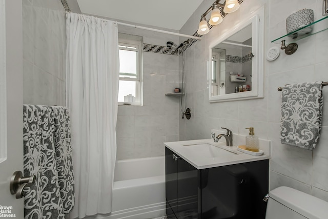 full bath featuring toilet, vanity, shower / bath combo with shower curtain, and tile walls