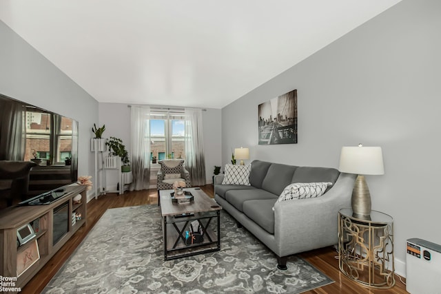 living area with baseboards and wood finished floors