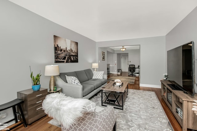 living area with baseboards and wood finished floors