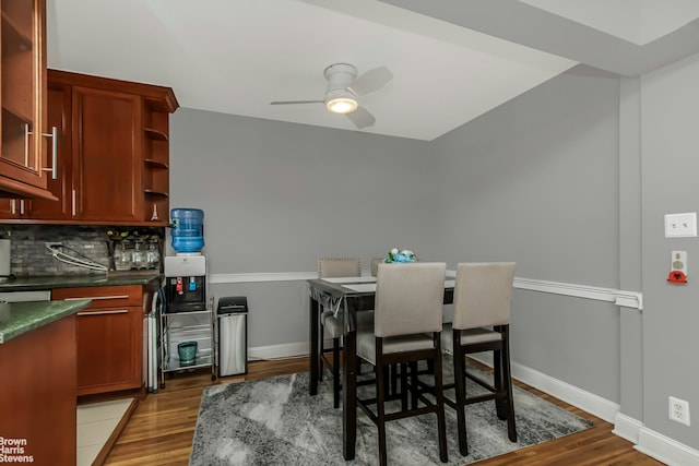 dining space featuring wood finished floors, baseboards, and ceiling fan
