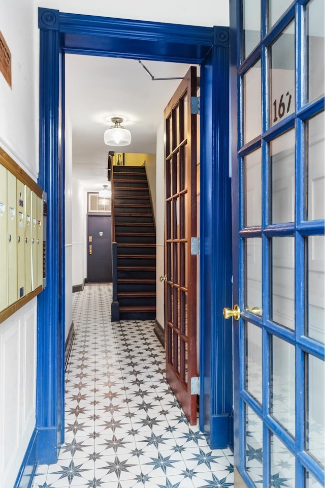 corridor with stairs, mail area, and tile patterned floors