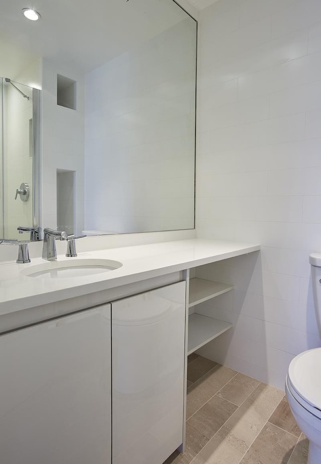 bathroom featuring tile walls, vanity, toilet, and recessed lighting